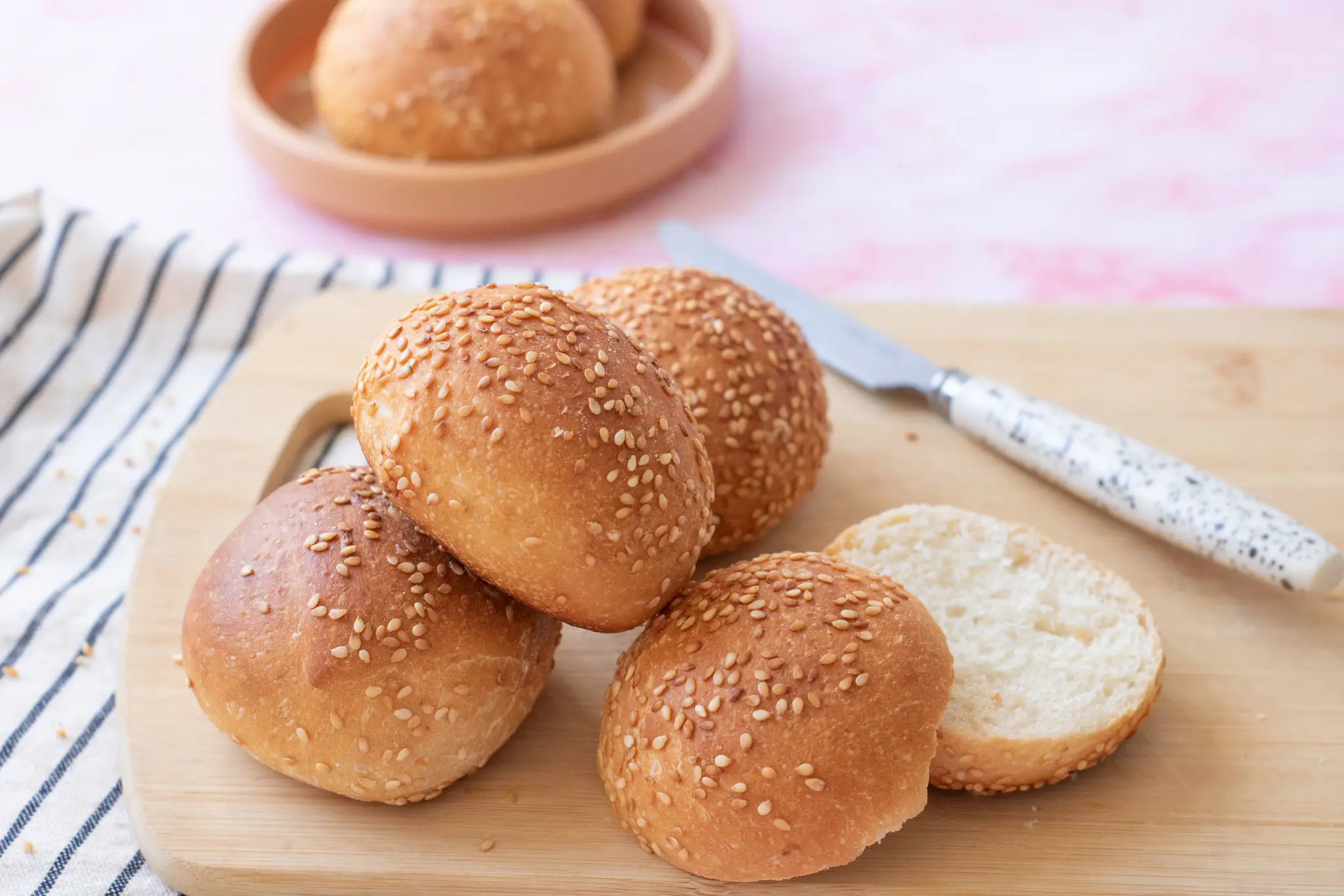 Sesame hamburger buns on a wooden board